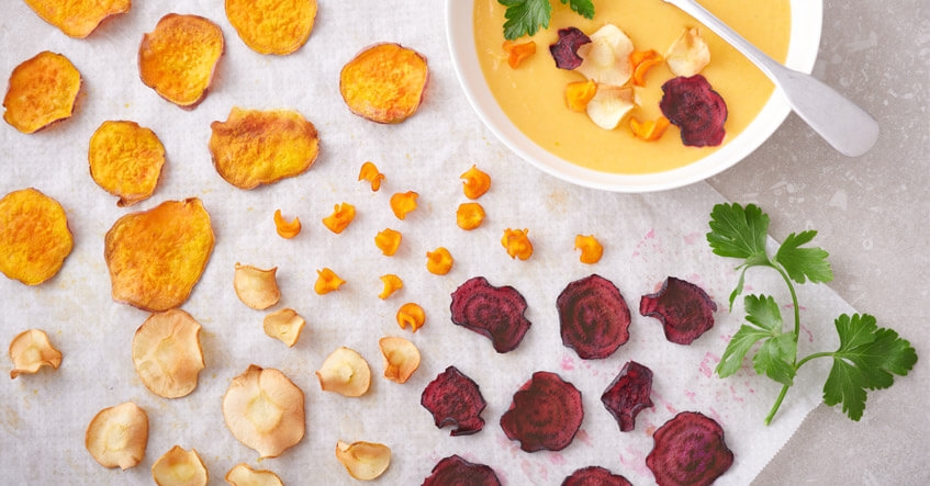 Chips de legumes feitos-cherovia,batata-doce, cenoura e beterraba sobre papel vegetal Albal®, com creme de batata-doce.